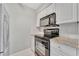 Kitchen showcasing modern appliances and granite countertops at 4827 Coquina Key Se Dr # B, St Petersburg, FL 33705