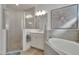 Tiled shower with glass door sits adjacent to the soaking tub with white cabinets and gray countertops at 1074 Signet Dr, Apollo Beach, FL 33572