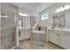 Bathroom with tile shower, soaking tub, dual sinks, white cabinets, and modern fixtures at 1074 Signet Dr, Apollo Beach, FL 33572