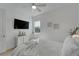 Bright bedroom features a ceiling fan, TV, artwork, and a lightly colored decor at 1074 Signet Dr, Apollo Beach, FL 33572