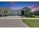 Beautiful blue home with a three-car garage, paver driveway, and lush tropical landscaping at 1074 Signet Dr, Apollo Beach, FL 33572