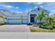 Charming one-story home featuring a three-car garage, brick driveway and tropical landscaping at 1074 Signet Dr, Apollo Beach, FL 33572