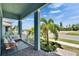 Cozy front porch with seating, columns, and a view of palm trees and the neighborhood at 1074 Signet Dr, Apollo Beach, FL 33572