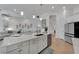 Open kitchen with island seating overlooks the living area, with modern finishes at 1074 Signet Dr, Apollo Beach, FL 33572