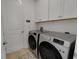 Updated laundry room features a washer and dryer, as well as cabinets for extra storage at 1074 Signet Dr, Apollo Beach, FL 33572