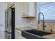 Modern kitchen with farmhouse sink, granite counters, and stainless steel appliances at 13118 Sorrento Way, Bradenton, FL 34211
