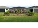 Expansive backyard featuring a screened lanai and landscaped garden with mature trees and a manicured lawn at 17702 Cresswind Ter, Bradenton, FL 34211