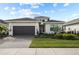 Beautiful single-story home with a dark gray garage door, tiled roof, and well-maintained landscaping at 17702 Cresswind Ter, Bradenton, FL 34211