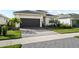 Charming single-story home featuring a dark gray garage door, tiled roof, and lush landscaping at 17702 Cresswind Ter, Bradenton, FL 34211