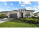 Attractive home with a well-kept lawn, mature landscaping, and a driveway that leads to an attached garage at 17702 Cresswind Ter, Bradenton, FL 34211