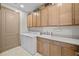Functional laundry room with ample storage cabinets, a sink, and modern washer and dryer at 17702 Cresswind Ter, Bradenton, FL 34211