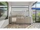 Well-equipped outdoor kitchen with stainless steel appliances and a built-in grill under a covered patio at 17702 Cresswind Ter, Bradenton, FL 34211