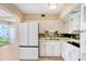 Kitchen with white cabinets, tile backsplash, and modern appliances at 2434 Australia E Way # 42, Clearwater, FL 33763