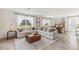 Spacious living room with light beige sofas and large windows overlooking a conservation area at 36023 Sunflower Hill Dr, Zephyrhills, FL 33541