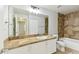 Bathroom with a large mirror, tile backsplash, white vanity, and a tub at 5606 Pinnacle Heights Cir # 304, Tampa, FL 33624