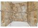 Tiled bathtub with shower and decorative mosaic tile border at 5606 Pinnacle Heights Cir # 304, Tampa, FL 33624