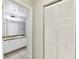 Hallway closet near a bathroom featuring a vanity with a sink and granite countertop at 5606 Pinnacle Heights Cir # 304, Tampa, FL 33624