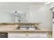 Kitchen featuring a breakfast bar with a double stainless steel sink and neutral countertops at 5606 Pinnacle Heights Cir # 304, Tampa, FL 33624