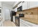 Well-equipped kitchen with white cabinets, black appliances, and ample countertop space at 5606 Pinnacle Heights Cir # 304, Tampa, FL 33624
