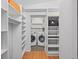 Bright laundry room with washer, dryer, and ample storage shelving at 11115 66Th Ter, Seminole, FL 33772