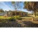 Backyard with covered patio, lush landscaping, and bird bath at 11116 Jenkins Ct, San Antonio, FL 33576