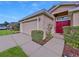 House exterior featuring a two-car garage and manicured landscaping at 11338 Southwind Lake Dr, Gibsonton, FL 33534