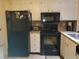Kitchen with black appliances and white cabinets at 12300 Vonn Rd # 6103, Largo, FL 33774