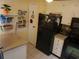 Galley kitchen with black appliances and granite countertops at 12300 Vonn Rd # 6103, Largo, FL 33774