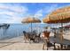 Outdoor patio with waterfront views, tables, chairs, and umbrellas at 1420 Bayshore Blvd # 209, Dunedin, FL 34698