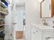 Updated bathroom with white vanity, built-in shelving, and hardwood floors at 213 W Cayuga St, Tampa, FL 33603