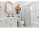 Clean bathroom with white vanity, subway tile, and striped shower curtain at 213 W Cayuga St, Tampa, FL 33603