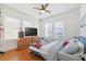 Comfortable bedroom with hardwood floors, ceiling fan, and large TV at 213 W Cayuga St, Tampa, FL 33603