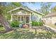 Charming craftsman home with a green exterior, porch, and well-maintained lawn at 213 W Cayuga St, Tampa, FL 33603