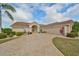 Lovely home with a tile roof, circular driveway, arched entry, and lush landscaping at 2337 Platinum Dr, Sun City Center, FL 33573