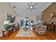 Cozy living room with hardwood floors, ceiling fan, comfortable seating, and sliding doors to the lanai at 2337 Platinum Dr, Sun City Center, FL 33573
