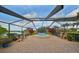 Spacious screened-in pool area with an octagonal-shaped jacuzzi, outdoor chairs, and lush greenery at 2337 Platinum Dr, Sun City Center, FL 33573