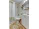 Well-lit bathroom with tiled floor featuring shower with curtain and vanity at 2460 Persian Dr # 26, Clearwater, FL 33763