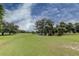 Lush green golf course with mature trees and a beautiful blue sky at 2460 Persian Dr # 26, Clearwater, FL 33763