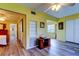 Hallway with bedroom and living room access, featuring wood floors and warm yellow walls at 2460 Persian Dr # 26, Clearwater, FL 33763