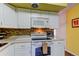 Well-maintained kitchen featuring white appliances and tile backsplash at 2460 Persian Dr # 26, Clearwater, FL 33763
