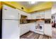 This bright kitchen features white cabinets and appliances with an open floorplan at 2460 Persian Dr # 26, Clearwater, FL 33763