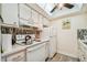 Efficient kitchen with white appliances and a colorful tile backsplash at 250 126Th Ave # 206, Treasure Island, FL 33706