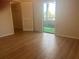 Bright bedroom featuring wood floors, closet, and access to an outdoor balcony space at 2593 Countryside Blvd # 7213, Clearwater, FL 33761