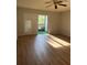 Spacious living room with laminate wood floors and sliding doors to balcony at 2593 Countryside Blvd # 7213, Clearwater, FL 33761