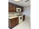 Modern kitchen with white appliances and wood cabinets at 2593 Countryside Blvd # 7213, Clearwater, FL 33761