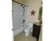 Cozy full bathroom with tub-shower, dark vanity, decorative star and neutral tile flooring at 262 Countryside Key Blvd, Oldsmar, FL 34677