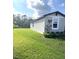 Side yard view of the house showing additional lawn space at 3050 Forrest Plum Ct, Zephyrhills, FL 33540