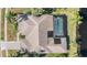 Aerial view of a home with a screened-in pool surrounded by lush greenery at 3360 Hickorywood Way, Tarpon Springs, FL 34688