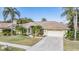 Charming single-story home with a two-car garage, lush landscaping, and a well-manicured lawn at 3360 Hickorywood Way, Tarpon Springs, FL 34688