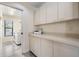 Functional laundry room with plenty of cabinets, a countertop, and a printer at 3360 Hickorywood Way, Tarpon Springs, FL 34688